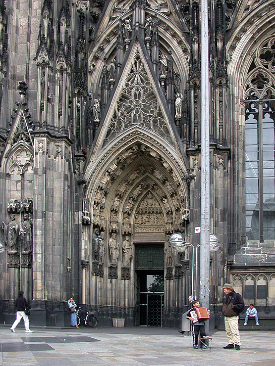 Devant la cathédrale de Cologne, Antoine en conversation avec un gamin musicien - 2002